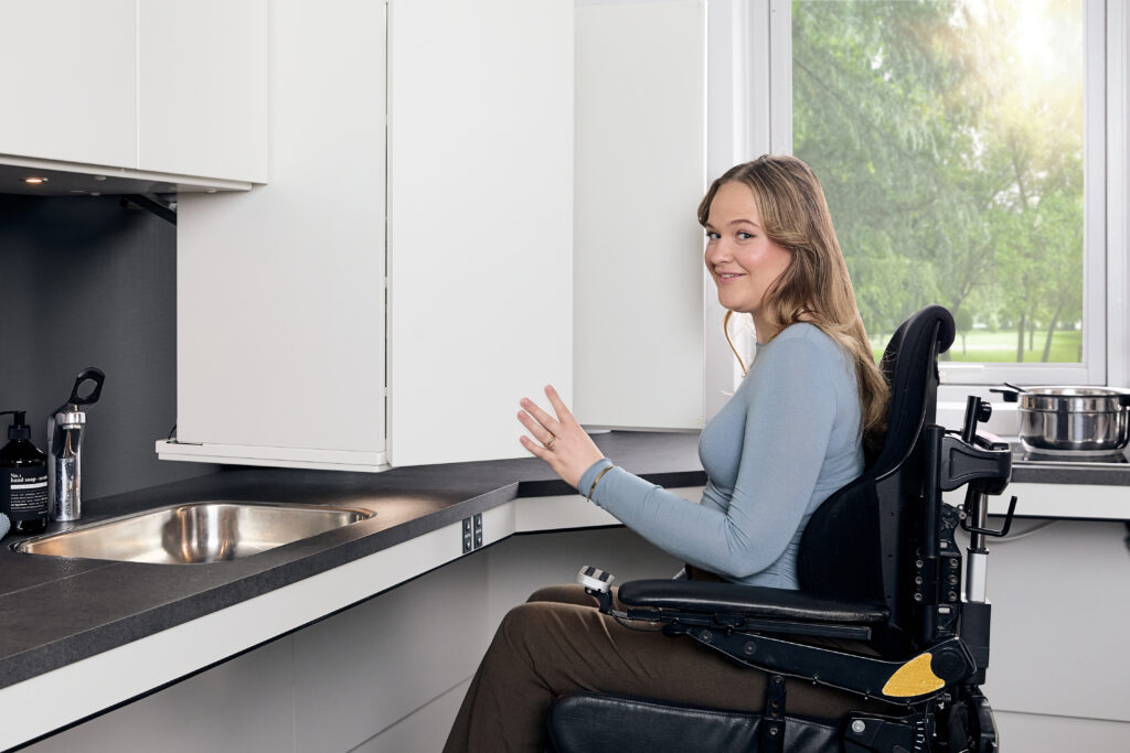 Ropox height-adjustable upper cabinet lowered to wheelchair user's reach